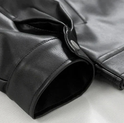 Man wearing a black oversized faux leather bomber jacket, styled casually for urban streetwear