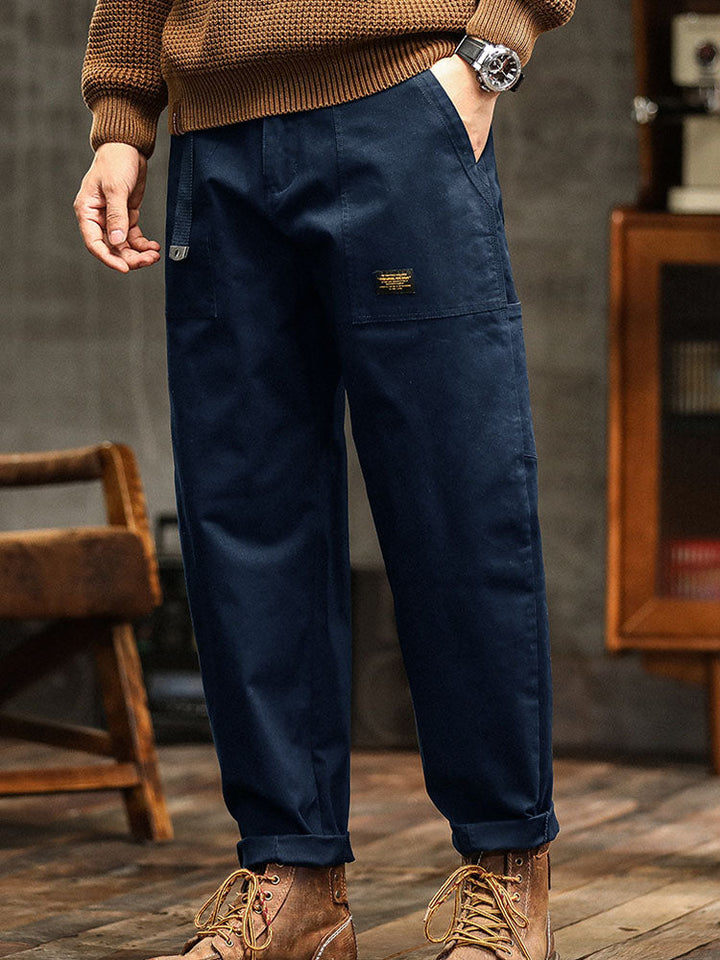 Fashionable men's utility pants with a relaxed fit, shown with a folded cuff for a modern, casual aesthetic.