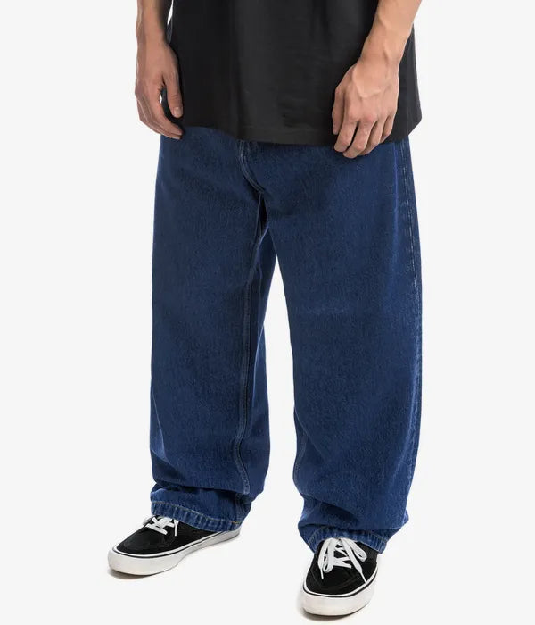 Detail of the button closure and belt loops on men's wide-leg denim pants, a staple for casual wear.