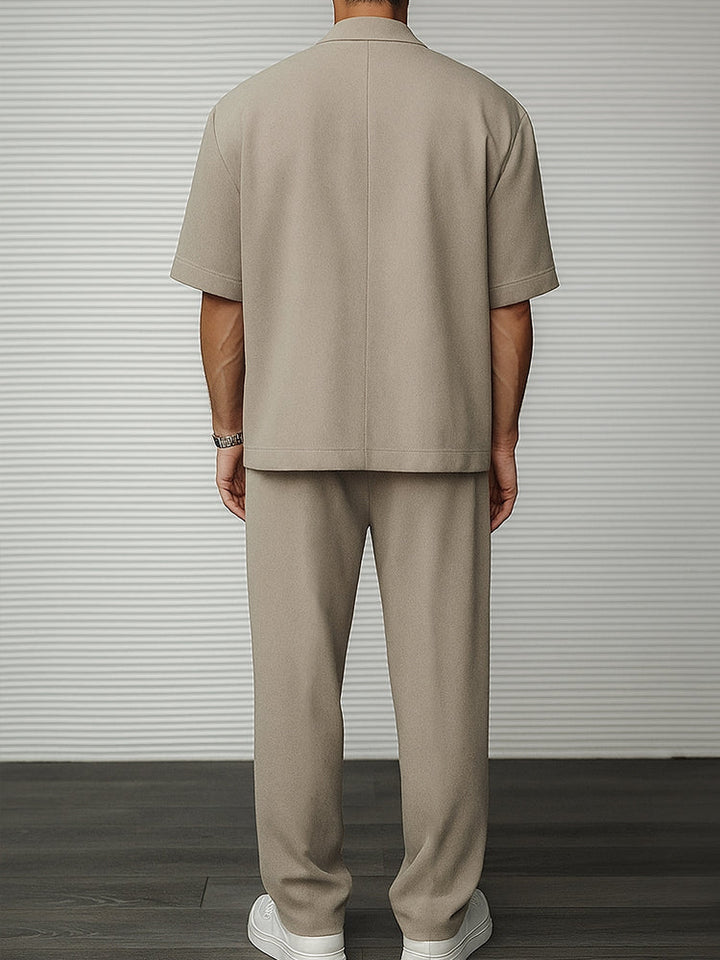 Man wearing a stylish men's short sleeve blazer & tailored trousers. Perfect smart casual ensemble for social events.