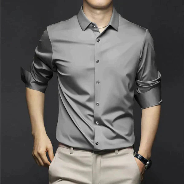 Man wearing a blue stretch slim fit dress shirt with a subtle pattern for spring fashion.