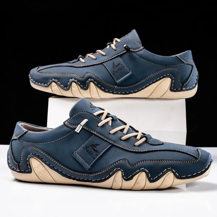 Men's low top lace-up sneakers with paneled design & contrast stitch.