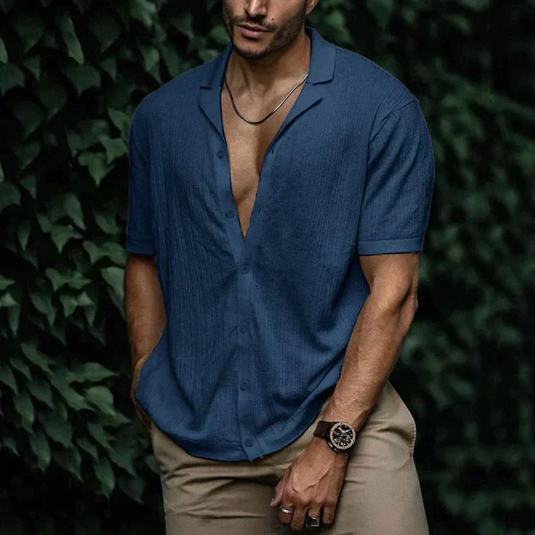 Button-down detail on a men's casual textured short sleeve Cuban collar shirt. Modern summer fashion.