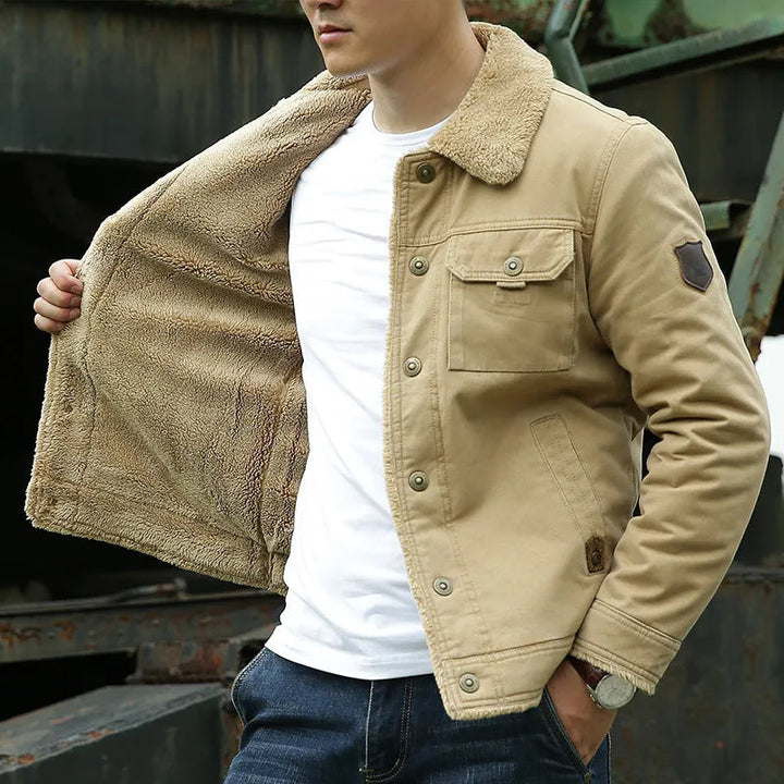 Close-up of a men's rugged jacket, highlighting its durable texture and the plush, warm faux fur collar. Casual menswear.
