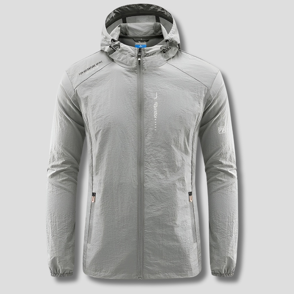Man hiking in an ultralight hooded windbreaker, offering sun protection for outdoor adventures & travel.
