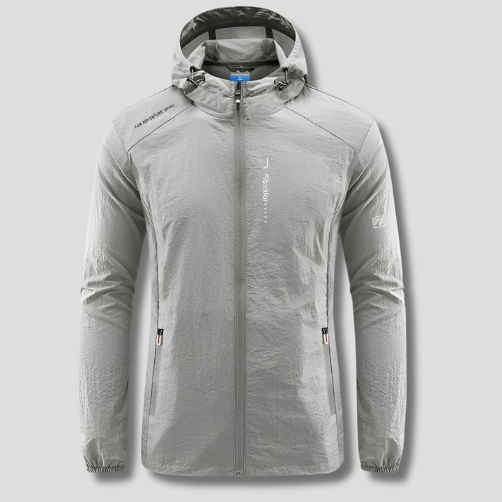 Man hiking in an ultralight hooded windbreaker, offering sun protection for outdoor adventures & travel.
