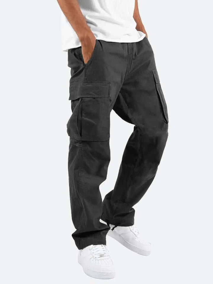 Utility men's cargo pants featuring multiple functional pockets & a comfortable drawstring waist, suitable for outdoor wear.