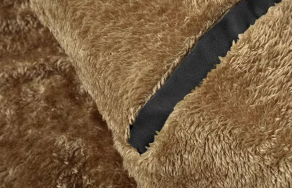 A stack of folded men's fur-lined parkas, showcasing various sizes