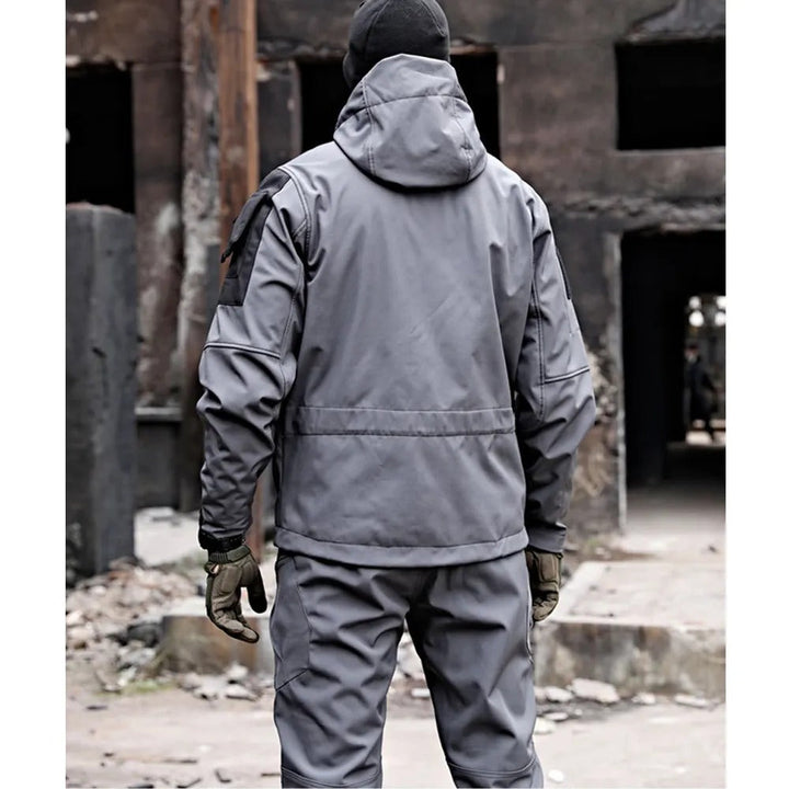 Man wearing Falk men's waterproof outdoor set. Jacket & trousers for hiking, offering windproof and rain protection.