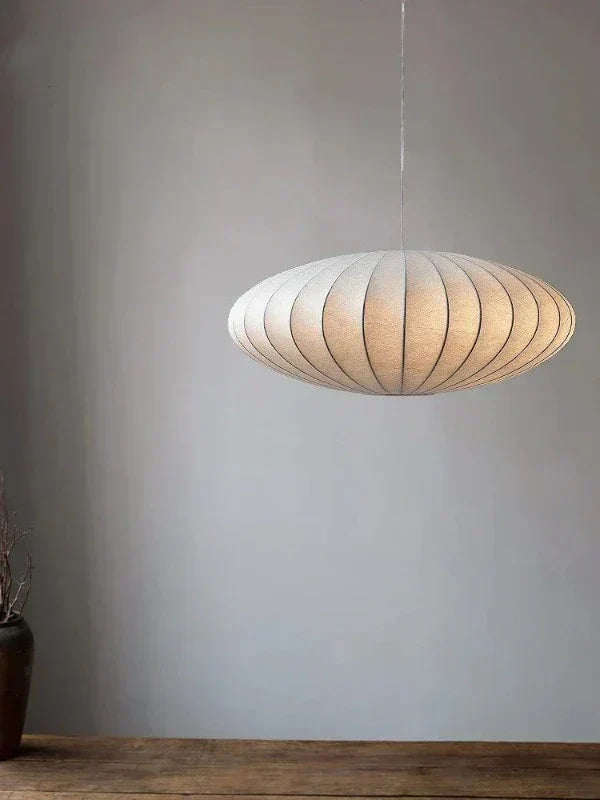 Modern crystal pendant light with silk lampshade for elegant dining room decor.