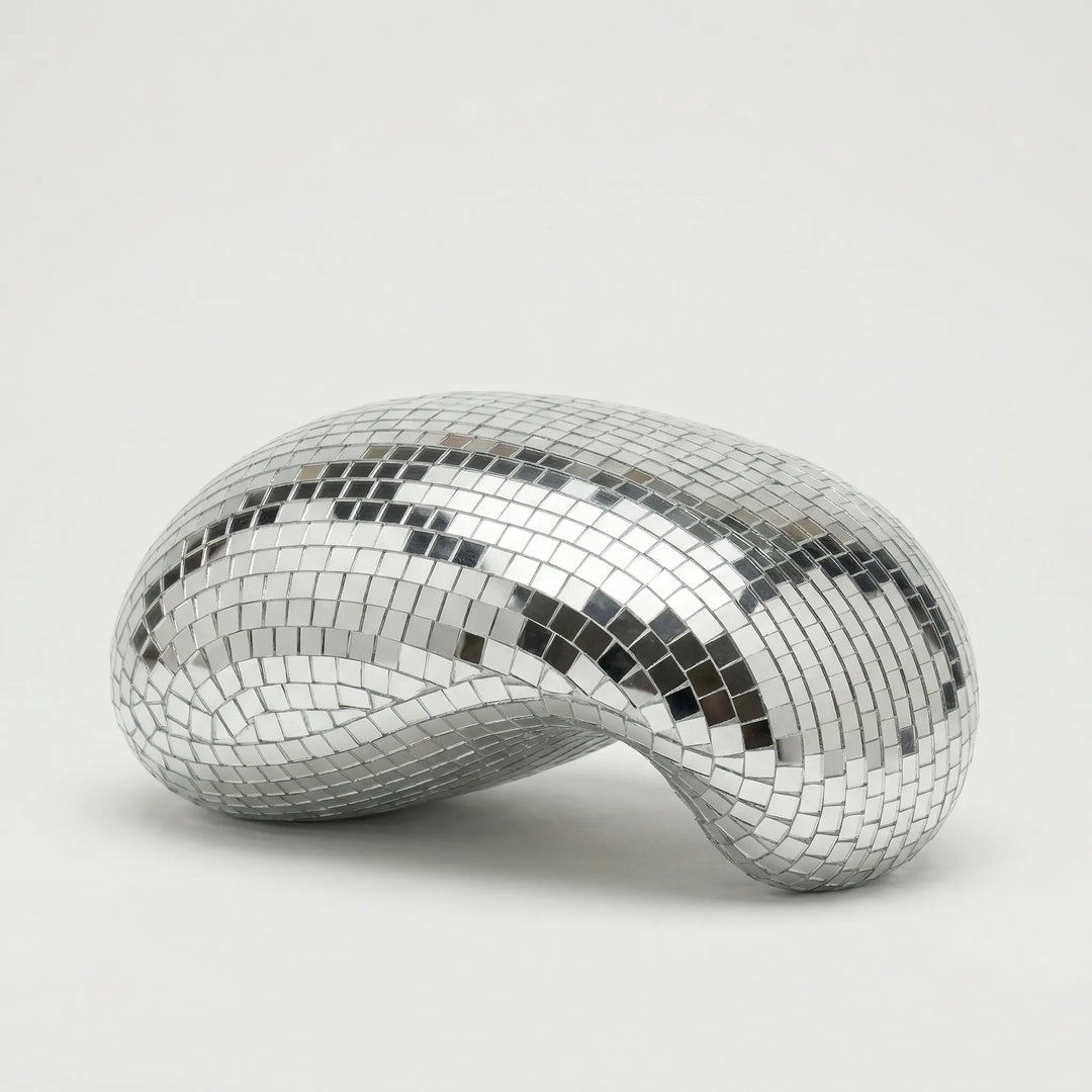 Sleek reflective tabletop sculpture, a modern art accent for contemporary home and office decor.