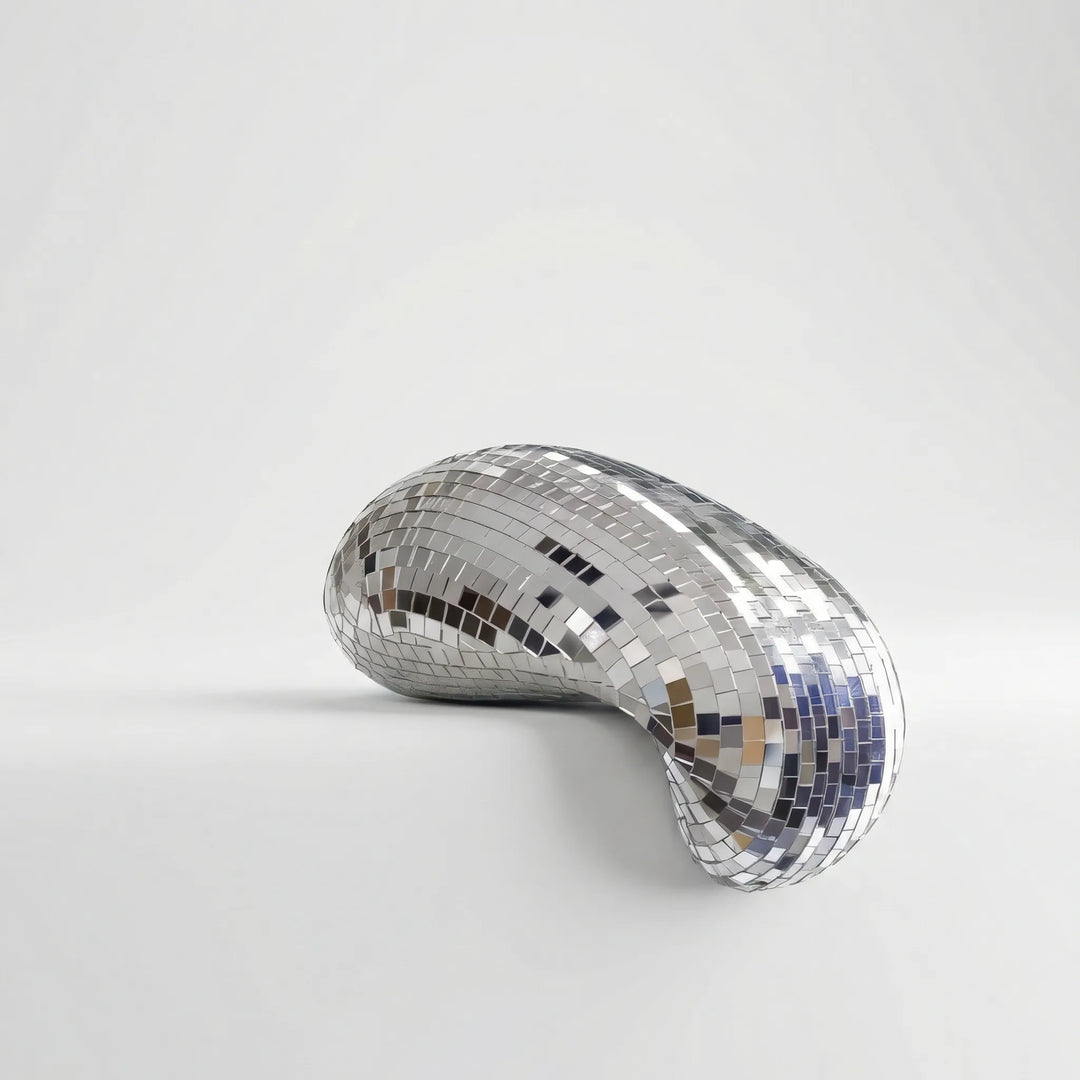 Gleaming modern reflective tabletop sculpture, an abstract art piece enhancing contemporary living spaces.