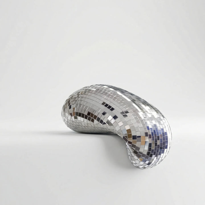 Gleaming modern reflective tabletop sculpture, an abstract art piece enhancing contemporary living spaces.