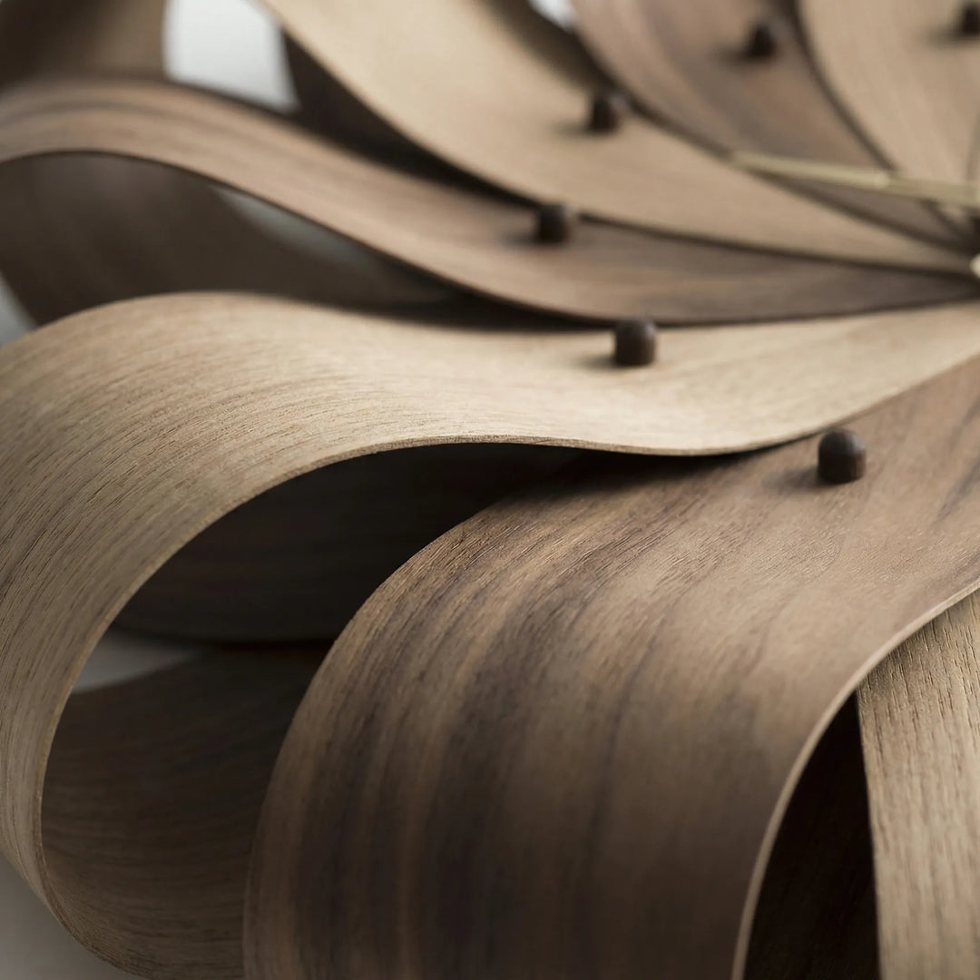 Close-up of a silent, modern sculptural wall clock. Stylish battery operated timepiece for contemporary decor.