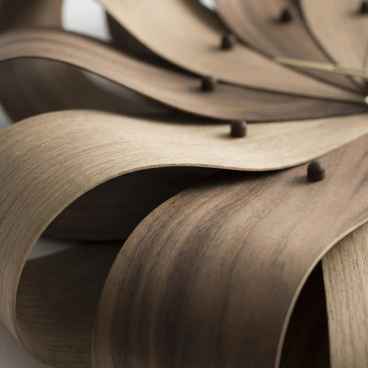 Close-up of a silent, modern sculptural wall clock. Stylish battery operated timepiece for contemporary decor.