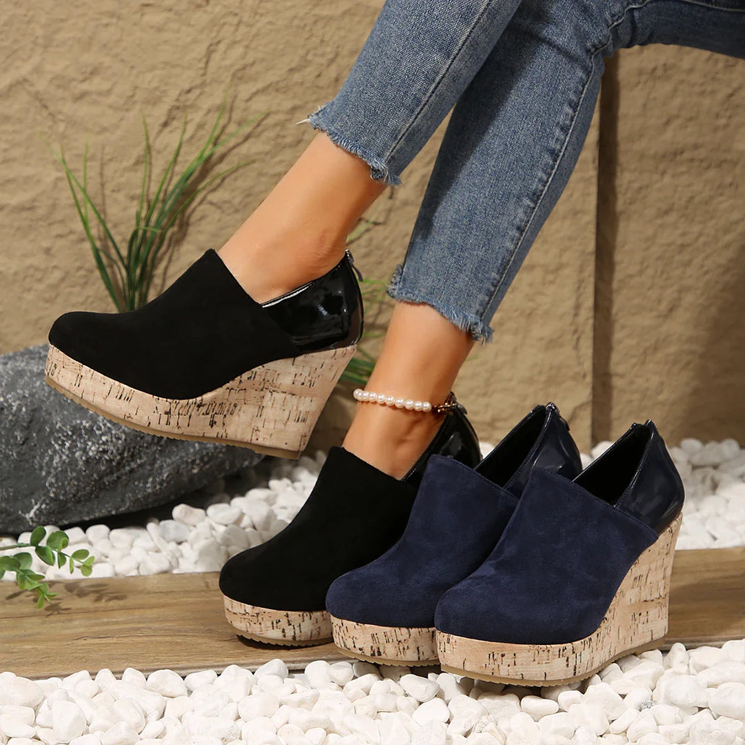 Woman's feet wearing comfortable navy blue orthopedic wedge loafers, casual outdoor setting