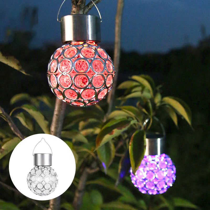 Waterproof solar hanging lantern suspended from a tree branch, casting a soft glow on the lawn.