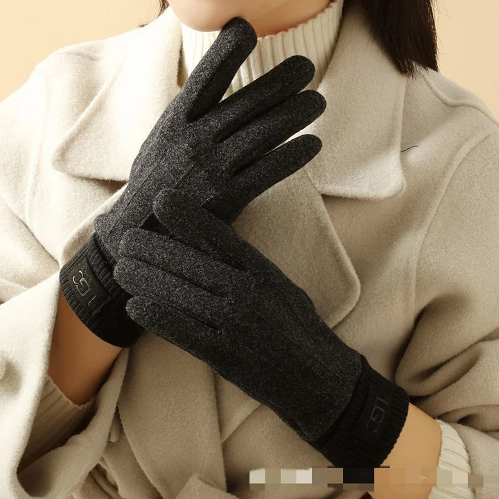 Female hand modeling a navy cashmere touchscreen winter glove, elegant and warm.