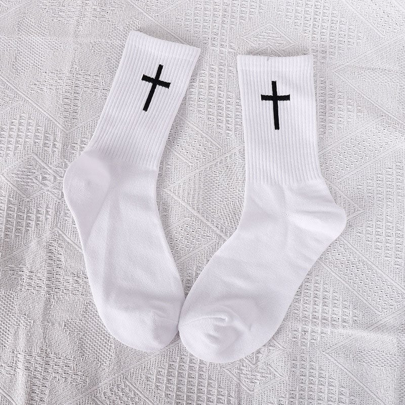 Three pairs of unisex ankle socks in black with white cross patterns, stacked