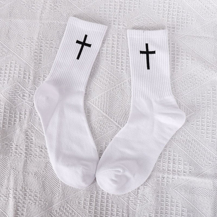Three pairs of unisex ankle socks in black with white cross patterns, stacked