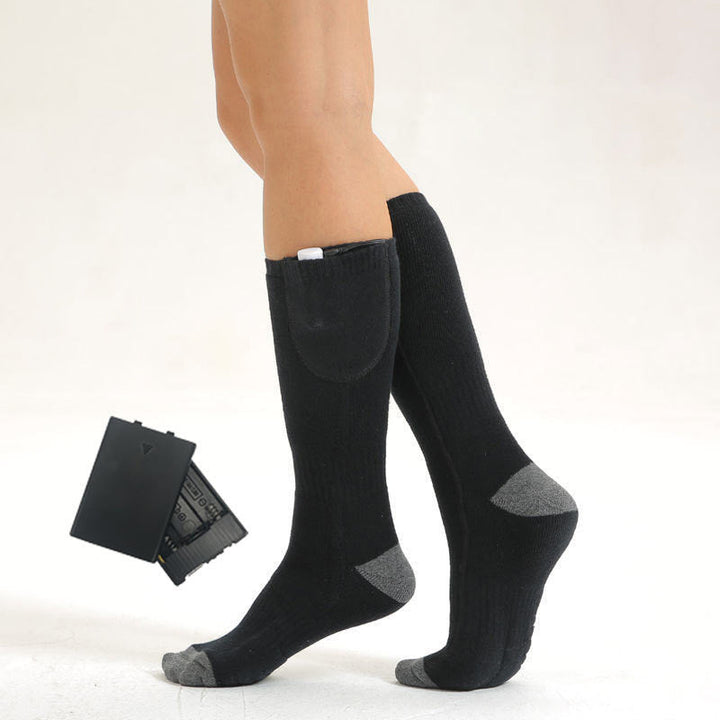 Pair of black heated socks against a backdrop of frost, highlighting their cold weather utility.