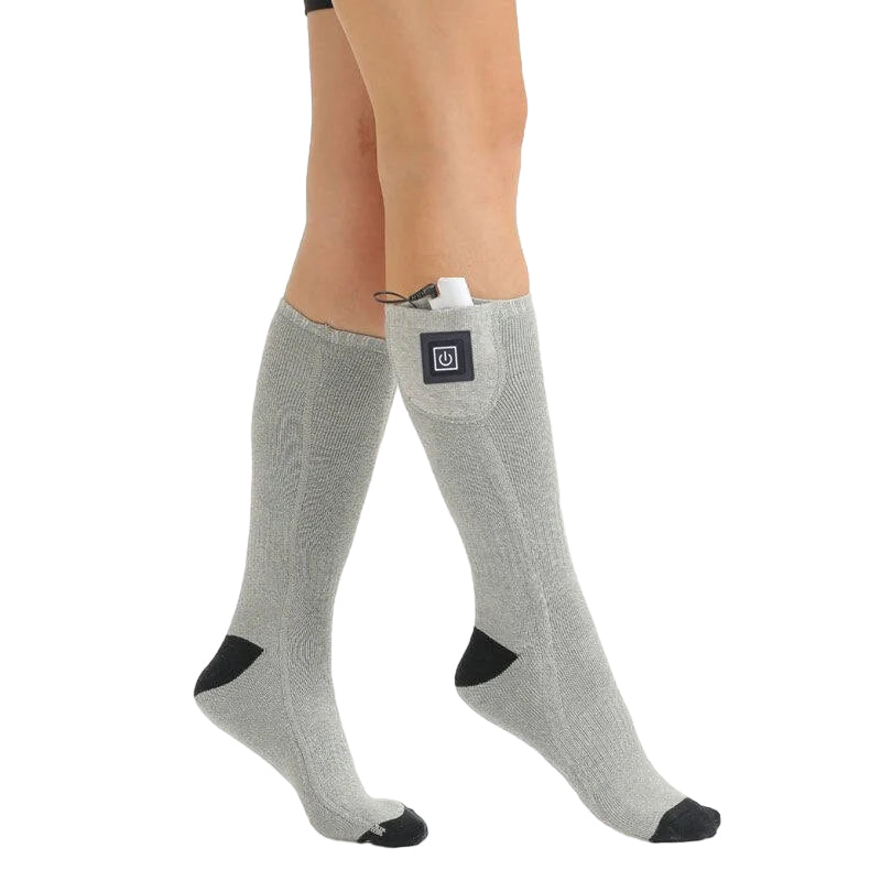Unisex thermal heated socks on a snowy mountain, ideal for winter hiking and outdoor gear.