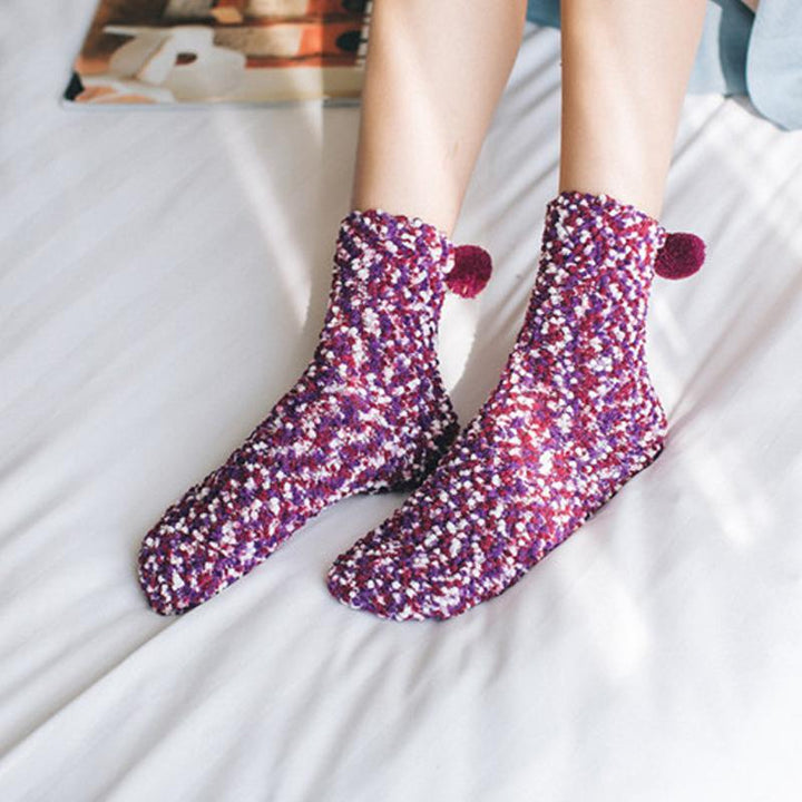 Side view of a woman's foot in a fluffy cupcake slipper sock, highlighting the plush interior and warmth.