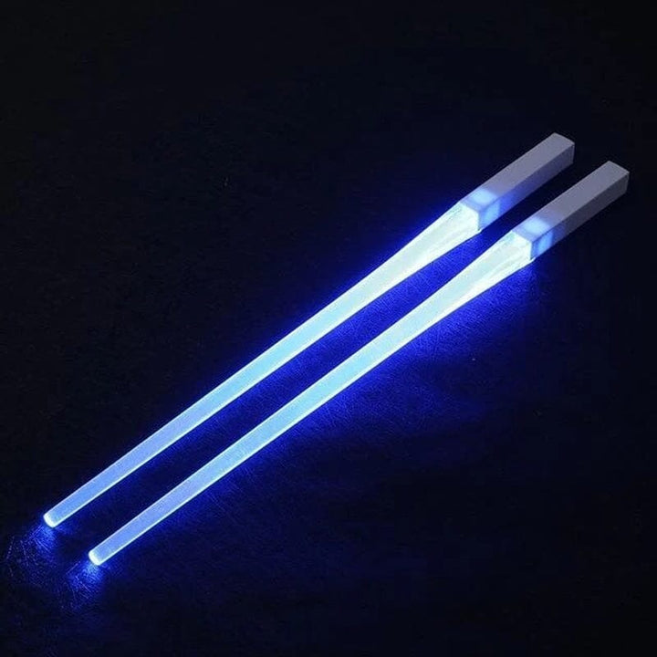 Luminous blue LED chopsticks on a black background, highlighting their bright, novelty design.