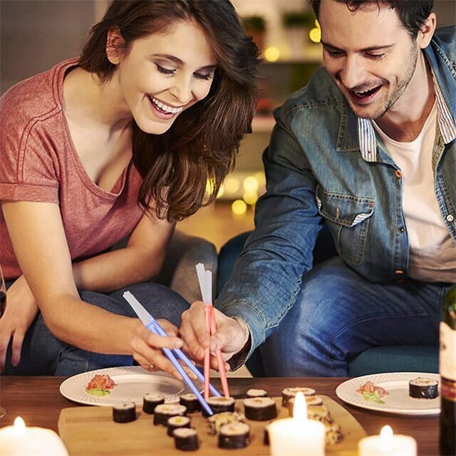 Blue glowing LED chopsticks on a dinner table, ready for a fun, luminous dining experience.