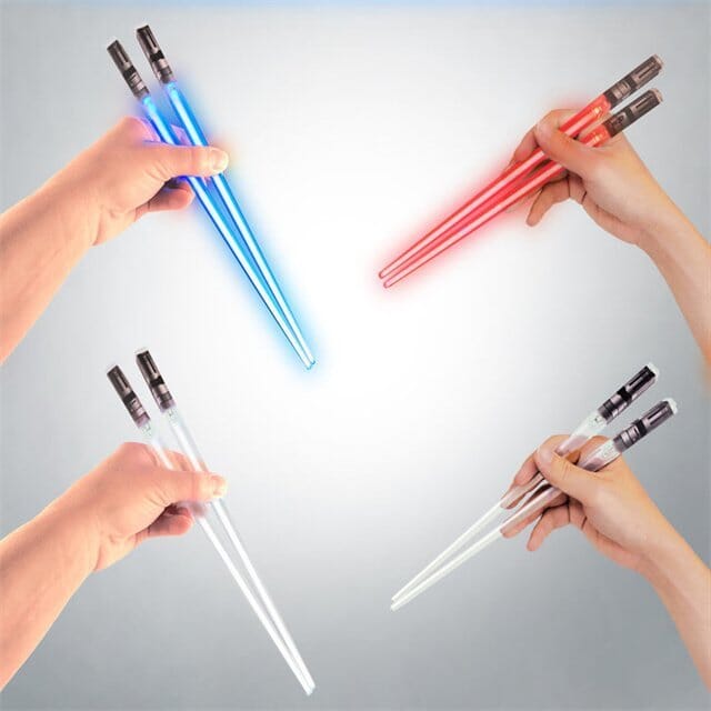 Hand holding a green glowing Lightsaber LED chopstick, demonstrating its luminous effect.