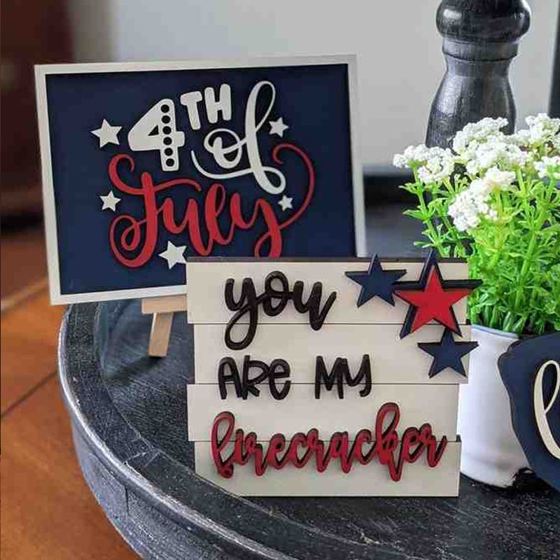 Closeup of a 'God Bless America' sign & wooden star from a patriotic tiered tray decor set.