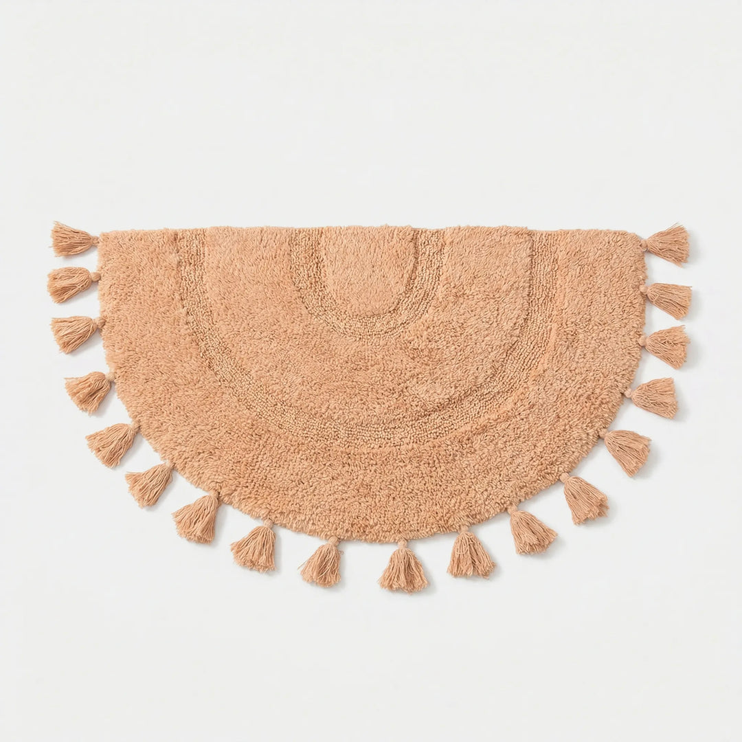 Flowique half circle accent rug in pink with playful tassels & wave design, perfect for nursery or entryway.