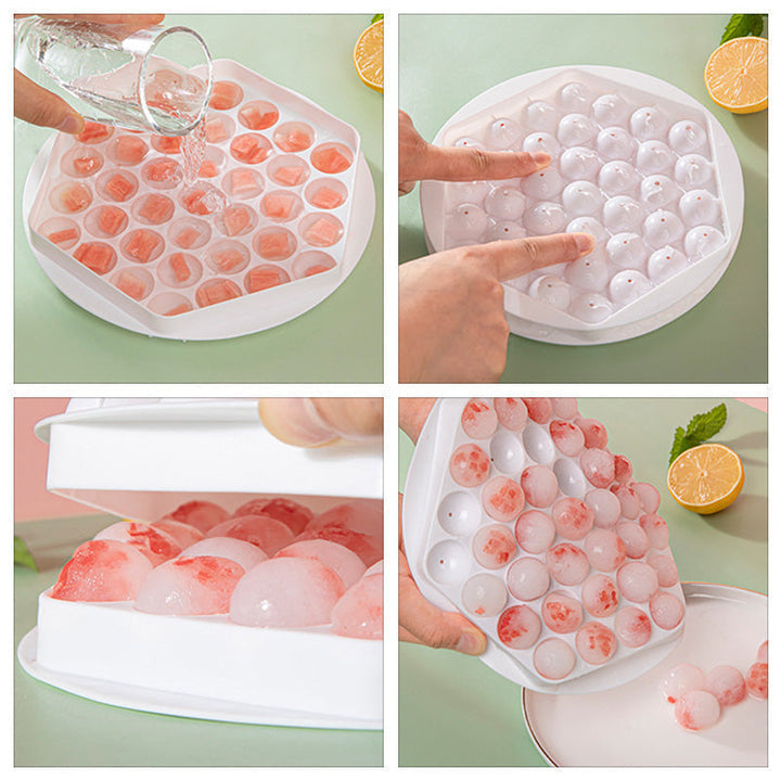 Kitchen counter with sphere ice ball maker molds in pink and blue, for cocktails.