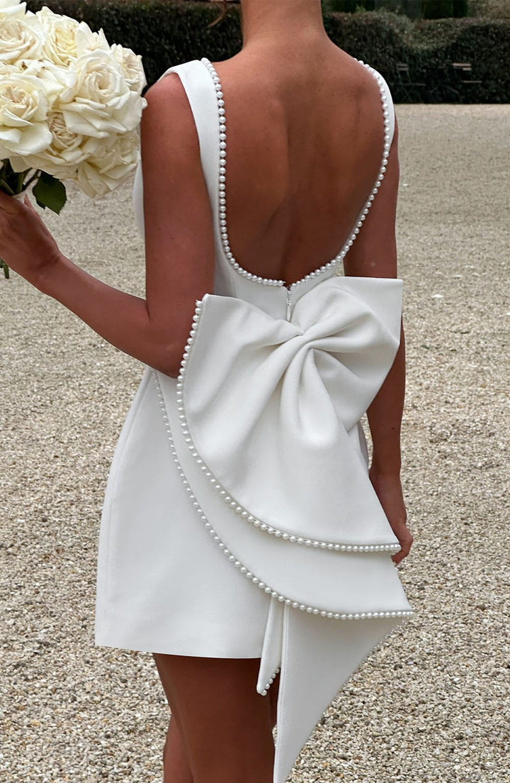 Full-length view of a woman wearing a structured mini dress, ideal for a wedding guest or party.