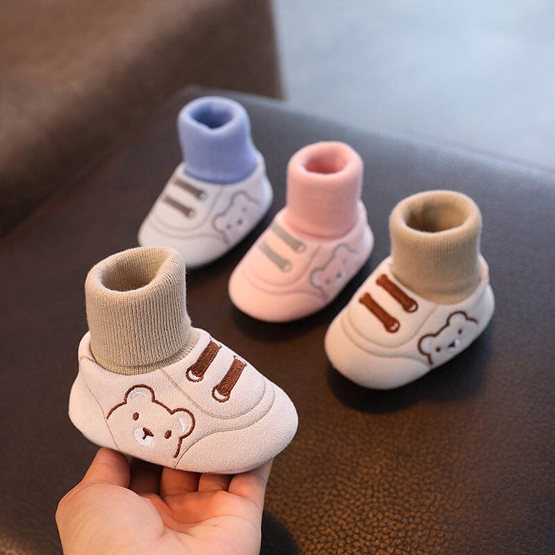 Close-up of a baby's foot wearing cozy plush winter booties with soft sole