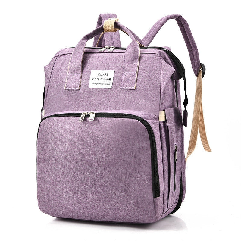Stylish travel backpack for parents, easily carries baby gear & converts to a portable bed.