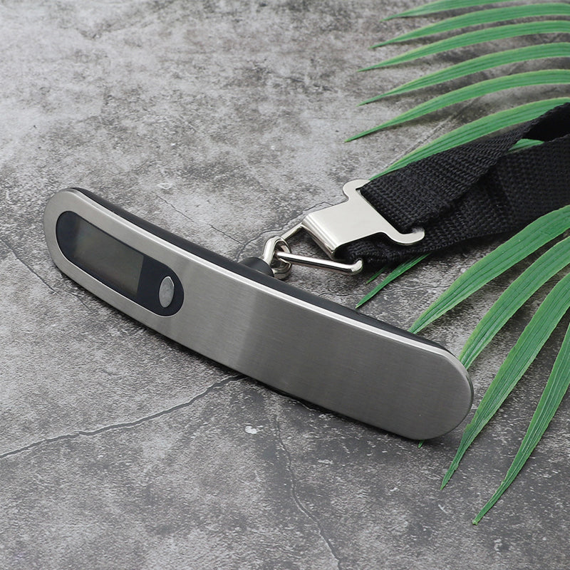 Hand holding a portable digital luggage scale, demonstrating its compact size and ease of use for weighing