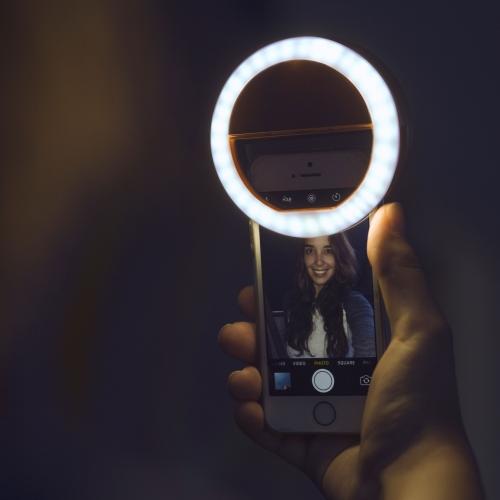 Compact, adjustable LED ring light for mobile phones. A portable tech accessory to brighten selfies & video calls.