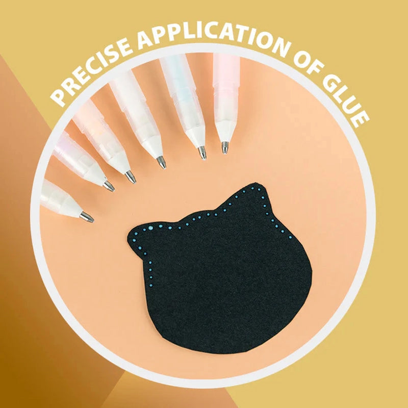 Hand holding Creative Precision Glue Pen, applying quick dry glue to paper for scrapbooking
