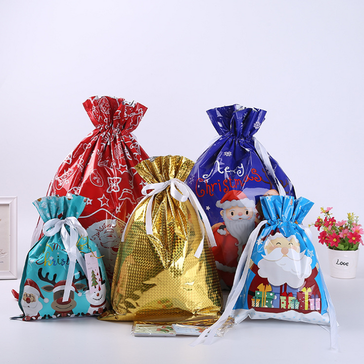 Assorted sizes of festive drawstring gift bags in red, green, and gold, for Christmas packaging.