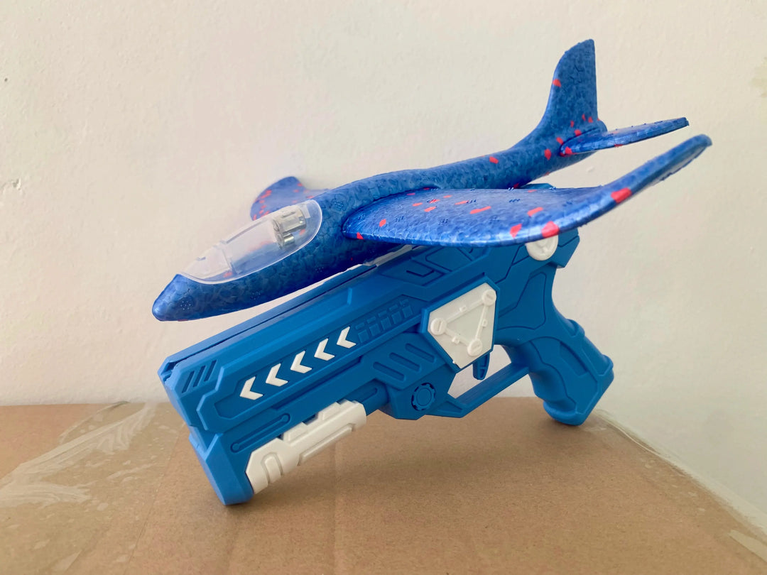 Glowing foam glider taking flight from a handheld launcher, great for kids' outdoor fun.