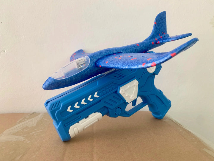 Glowing foam glider taking flight from a handheld launcher, great for kids' outdoor fun.