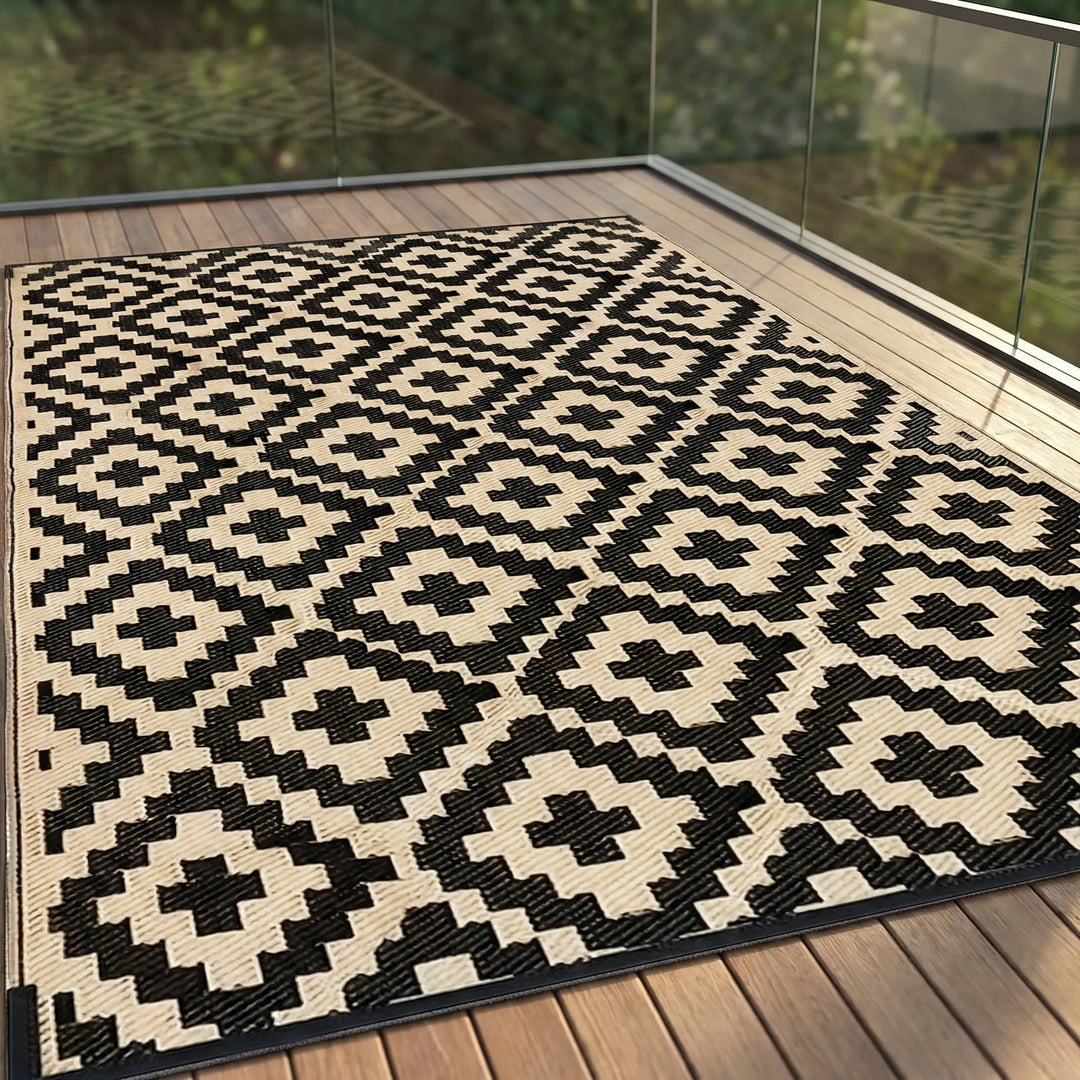 Reversible Flowique outdoor area rug for patio, featuring modern geometric waves. Weather-resistant & easy clean.