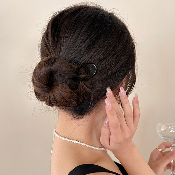 Hair pins scattered on a white surface, emphasizing their simplicity for women's hair styling.