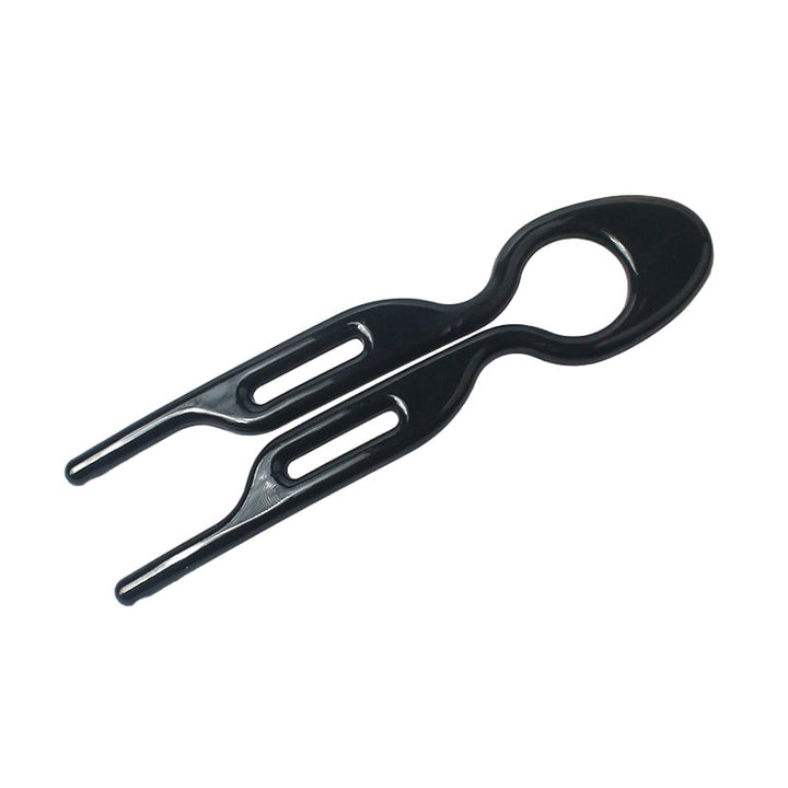 A hand holding a single black hair pin, illustrating its size and ease of use for updos.