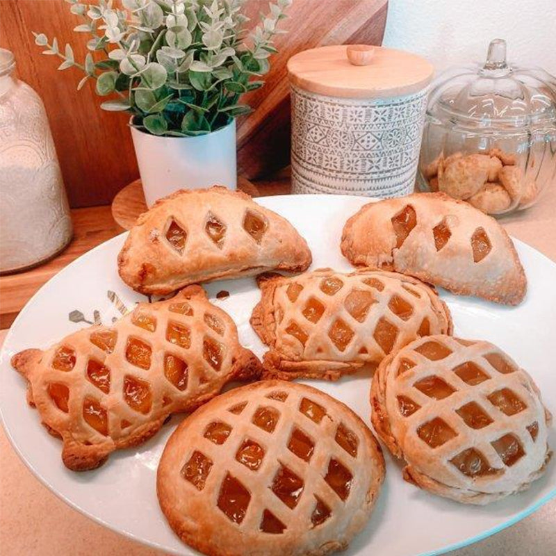 Kitchen counter with various mini hand pie molds and ingredients for making homemade dessert or savory snacks