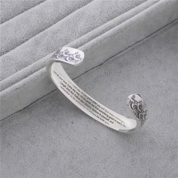 Granddaughter love message cuff bracelet on a teenage girl's wrist, close-up, worn on arm