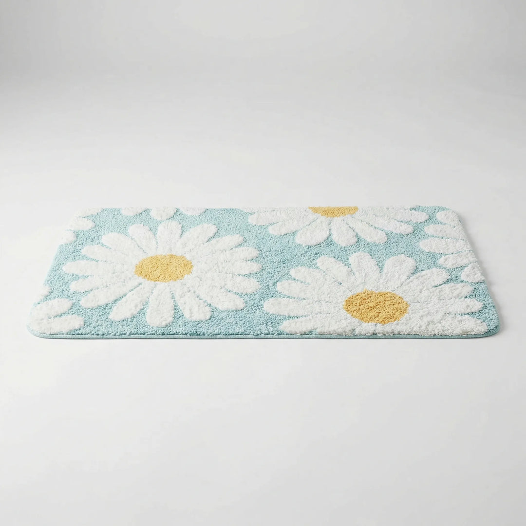 Plush daisy bath mat for soft underfoot comfort. Absorbent floral bathroom rug with a unique wave pattern.