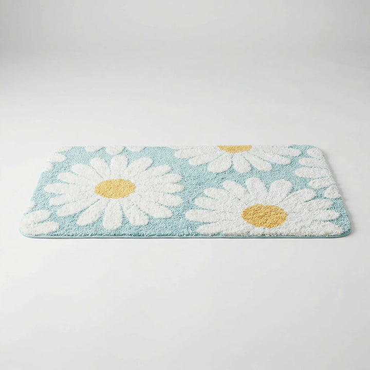 Plush daisy bath mat for soft underfoot comfort. Absorbent floral bathroom rug with a unique wave pattern.