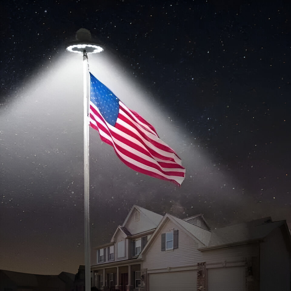Weatherproof solar LED flagpole light illuminating a flag at night. Automatic outdoor flag display.